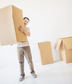 Mid adult moving cardboard boxes. Photo : Daniel Grill
