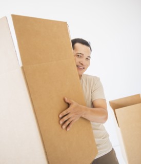 Mid adult moving cardboard boxes. Photo : Daniel Grill
