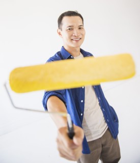 Man holding painting roll. Photo : Daniel Grill