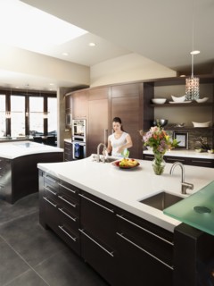 Young woman bustling around in modern domestic kitchen.