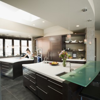 Young woman bustling around in modern domestic kitchen.