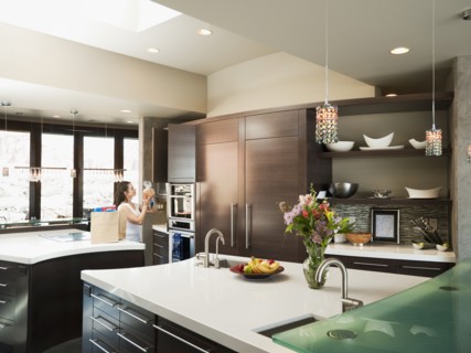 Young woman bustling around in modern domestic kitchen.