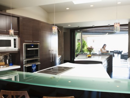 Young woman bustling around in modern domestic kitchen.