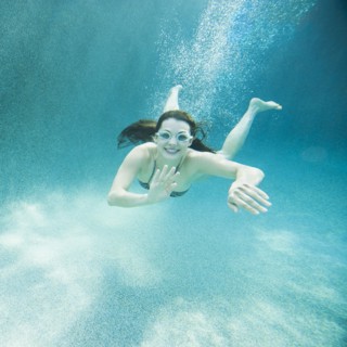 Young attractive woman diving in swimming pool. Photo: Erik Isakson