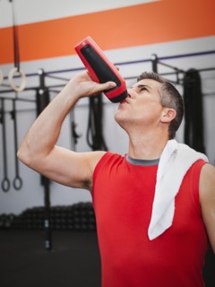 Mature man drinking while taking break from exercising.