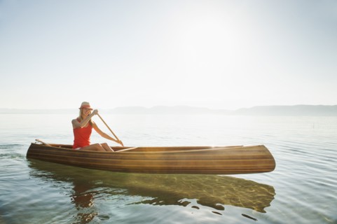 Portrait of young woman paddling canoe.