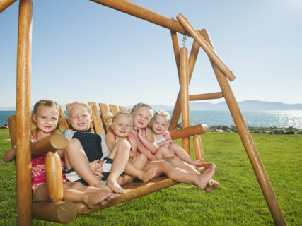 Portrait of children (2-3, 4-5) on swing.