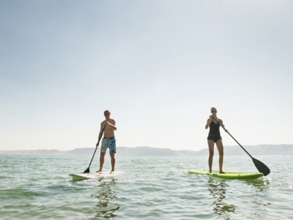 Two people standing on paddleboard.