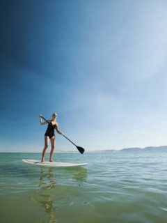 Young woman standing on paddleboard.