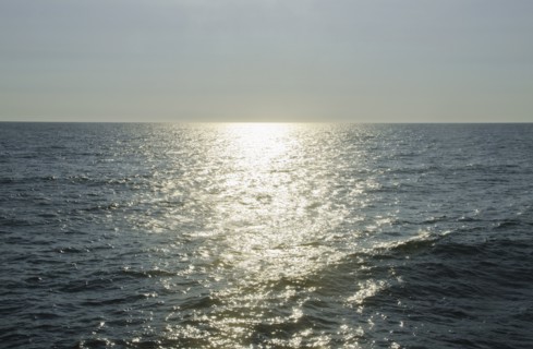 sunlight reflecting on sea. Photo : Tetra Images