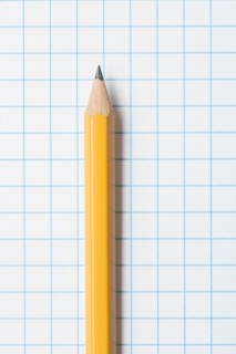 Close up of single yellow sharpened pencil on graph paper. Photo : Kristin Duvall