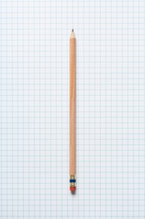 Single wooden sharpened pencil on graph paper. Photo : Kristin Duvall