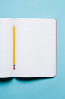 Single yellow sharpened pencil with blank composition notebook. Photo : Kristin Duvall