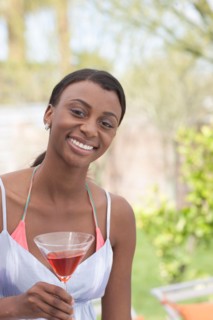 African American woman with drink at garden party. Photo : Dan Bannister