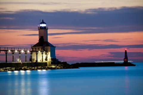 Michigan City Lighthouse at sunset. Chicago skyscrapers seen far in background.. Photo : Henryk
