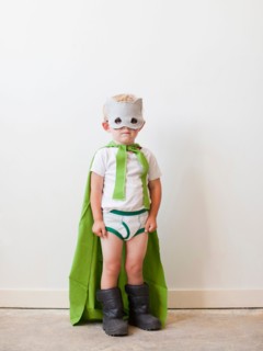 Studio shot, Portrait of boy (2-5 years) wearing green cape and mask. Photo : Jessica Peterson