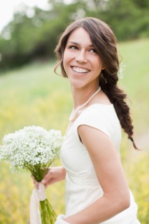 Portrait of happy woman holding flowers and smiling. Photo : Jessica Peterson