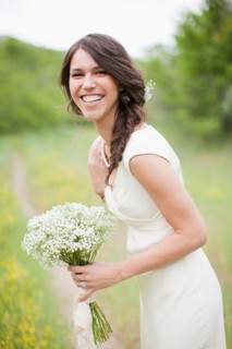 Portrait of happy woman holding flowers and smiling. Photo : Jessica Peterson