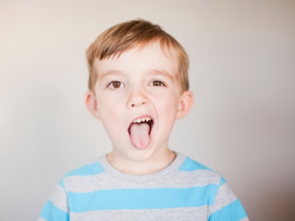 Studio Shot, Portrait of boy sticking out his tounge. Photo: Jessica Peterson