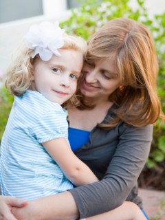 Portrait of mother and her daughter sitting on her lap. Photo : Jessica Peterson