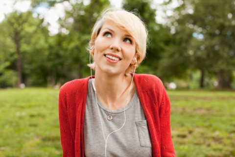 Portrait of smiling woman listening to music. Photo : Jessica Peterson