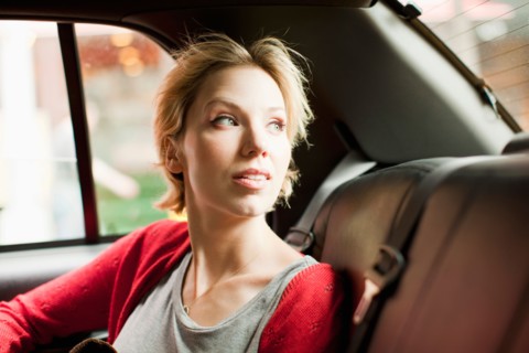 Portrait of woman on back seat of car. Photo : Jessica Peterson
