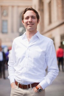 Portrait of man wearing white shirt and holding hands in his pockets. Photo : Jessica Peterson