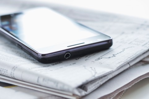 Smartphone on newspaper.