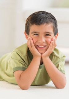 Portrait of boy (6-7) lying on carpet.