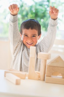 Boy (6-7) playing with toy blocks.