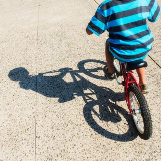Low section of boy (6-7) riding bicycle.
