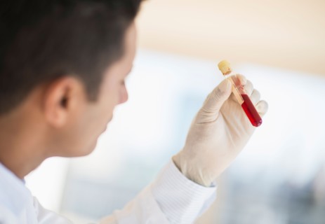 Technician holding blood sample.