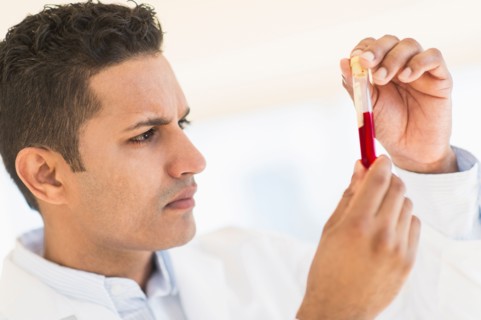 Technician examining blood sample.