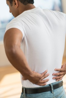 Man massaging his back.