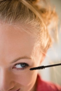 Close up of young woman using mascara