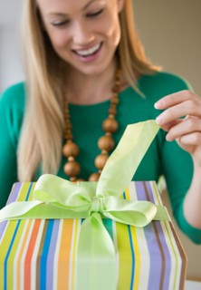 Smiling young woman opening birthday present