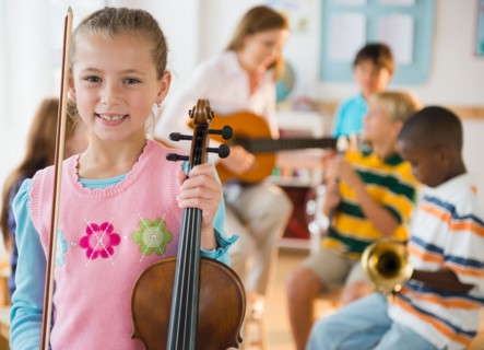 Portrait of schoolgirl (8-9) with violin during music class