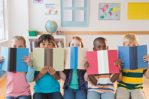School children (8-9) sitting in row with open books