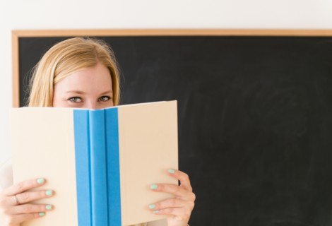 Portrait of woman shielding her face with book