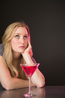 Young woman drinking martini and contemplating