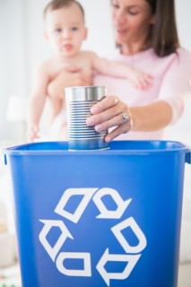 Mother and daughter (6-11 months) putting can into recycling bin