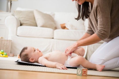 Mother changing diaper to daughter (6-11 months)
