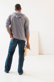 Young man standing against white canvas