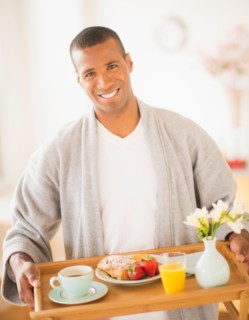 Young man holding breakfast tray