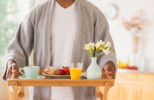 Young man holding breakfast tray
