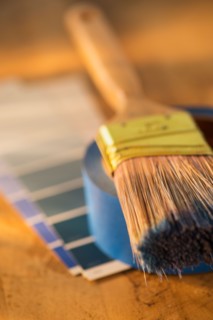 Elevated view of paintbrush, masking tape and color swatches