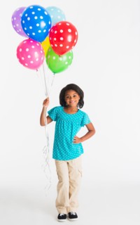 Studio shot of girl (6-7 years) holding colorful balloons