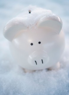 Studio shot of white piggy bank on artificial snow