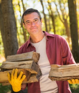 Portrait of Man holding armful of logs