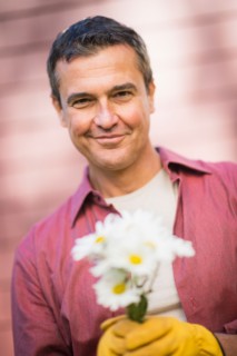 Portrait of smiling man holding flowers